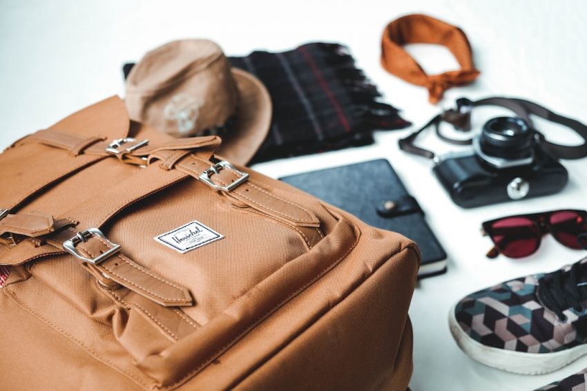 Accessorize - closeup photo of brown leather bag near sunglasses and shoes